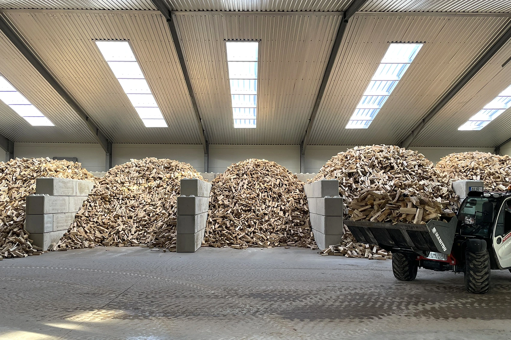 Großes Holzlager mit ofenfertigem Brennholz in Verkaufsboxen